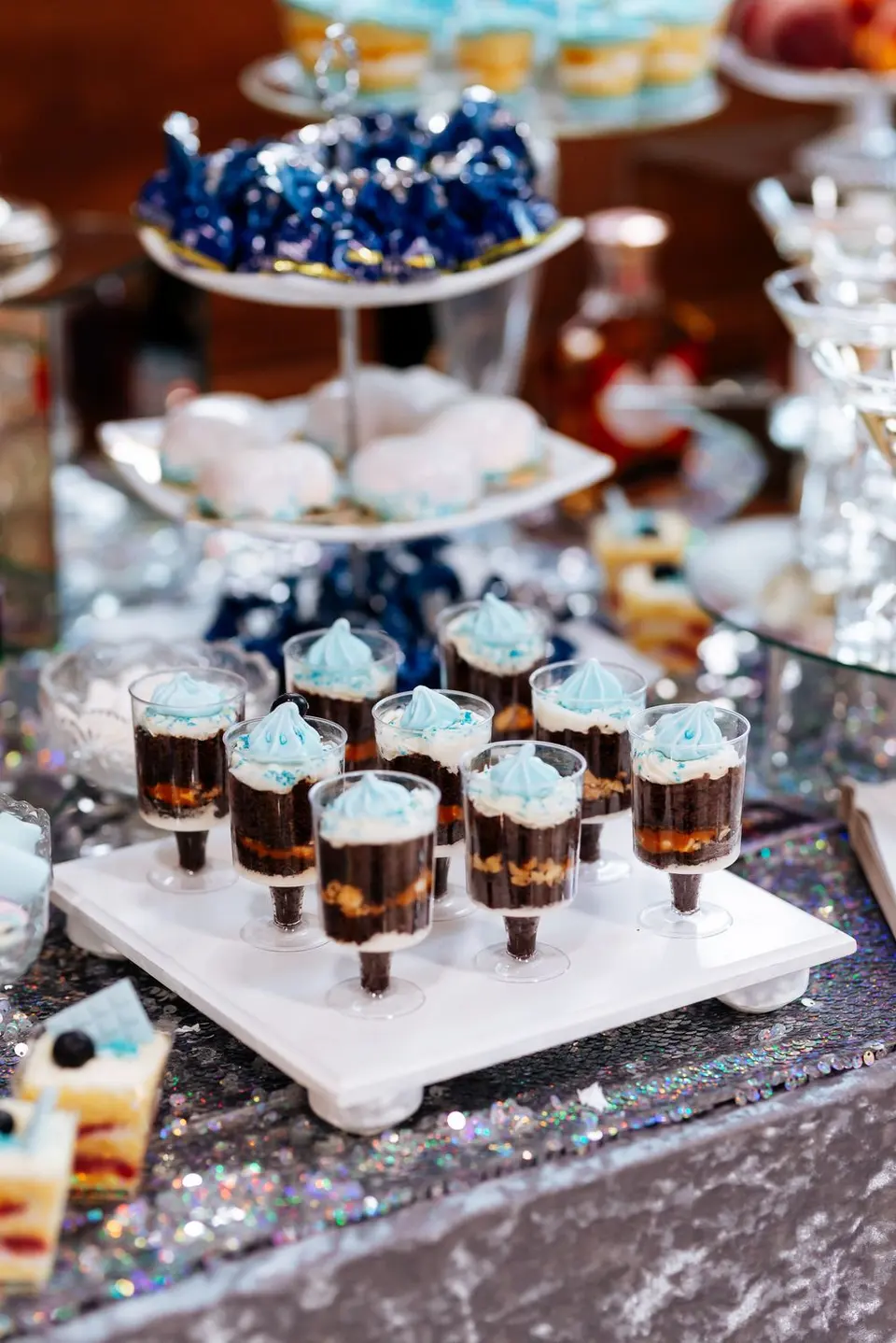 Mesa de dulces con postres en vasitos y bandejas